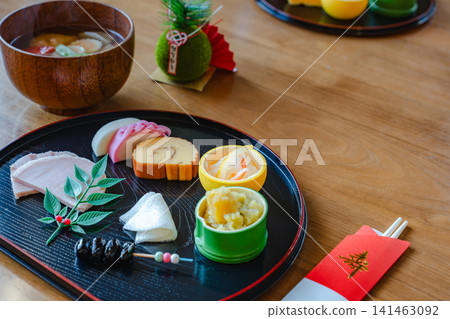 A beautiful New Year's table setting with traditional New Year's dishes and miso soup. A beautiful New Year's table setting with traditional New Year's dishes and miso soup. 141463092