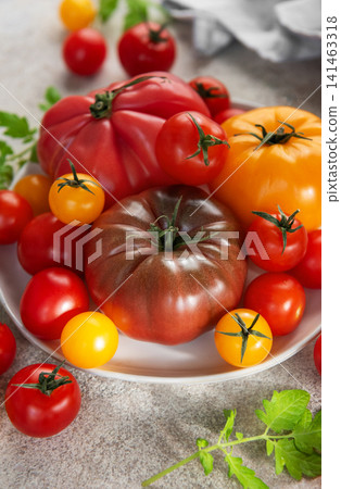 Fresh organic heirloom tomatoes creating colorful healthy food display Fresh organic heirloom tomatoes creating colorful healthy food display 141463318