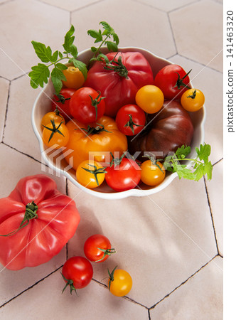 Fresh organic heirloom tomatoes in white bowl Fresh organic heirloom tomatoes in white bowl 141463320
