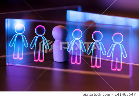 Abstract representation of individuality with a central wooden figure surrounded by glowing holographic human icons in blue and pink colors on a dark background Abstract representation of individuality with a central wooden figure surrounded by glowing holographic human icons in blue and pink colors on a dark background 141463547