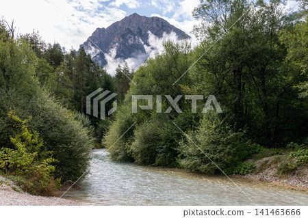 Alpine river curving through forest below a massive Dolomite peak, near San Vigilio di Marebbe Alpine river curving through forest below a massive Dolomite peak, near San Vigilio di Marebbe 141463666