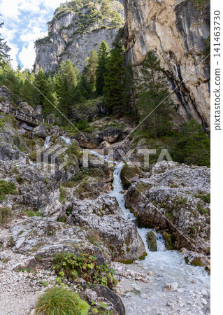 Rocky Ciastlins cascade flowing below a wooden footbridge in South Tyrol, Italy 141463730