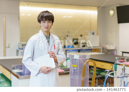 Portrait of a young male researcher standing with a laptop computer. Photography assistance provided by: Denpa Gakuen Educational Foundation, Tokyo Electronics College. Portrait of a young male researcher standing with a laptop computer. Photography assistance provided by: Denpa Gakuen Educational Foundation, Tokyo Electronics College. 141463771