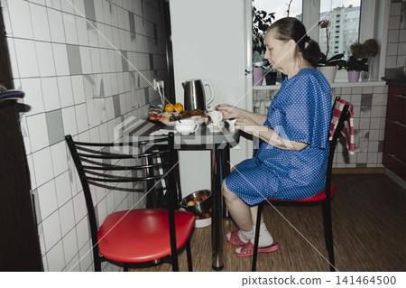 poised elderly woman in a blue dotted dress enjoys a quiet cup tea in retro style kitchen, her serene expression warm domestic setting evoking nostalgia, comfort simple pleasure of a peaceful moment poised elderly woman in a blue dotted dress enjoys a quiet cup tea in retro style kitchen, her serene expression warm domestic setting evoking nostalgia, comfort simple pleasure of a peaceful moment 141464500