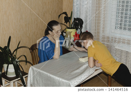 caring grandmother gently measures her grandsons blood pressure home monitor intimate domestic scene highlighting family support, health awareness quiet trust between generations warm familiar setting caring grandmother gently measures her grandsons blood pressure home monitor intimate domestic scene highlighting family support, health awareness quiet trust between generations warm familiar setting 141464516