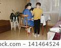 gentle grandmother blue top patiently shows her young grandson how sew piece fabric focused collaboration capturing warmth family learning passing traditions quiet joy creating something together 141464524