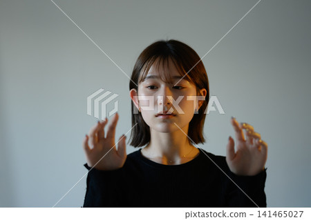 A woman holding both hands out in front of her. A woman holding both hands out in front of her. 141465027