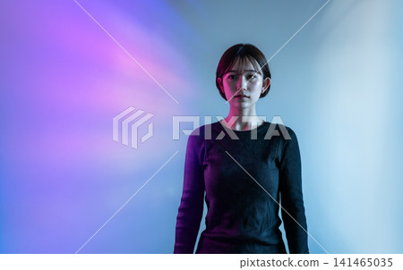 A young woman illuminated by colorful lights A young woman illuminated by colorful lights 141465035