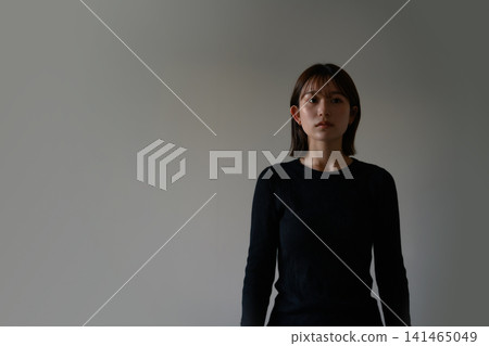 A woman staring straight at the wall. 141465049