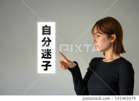A young woman pointing her finger, against a simple background. A young woman pointing her finger, against a simple background. 141465074