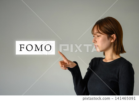 A young woman pointing her finger, against a simple background. A young woman pointing her finger, against a simple background. 141465091