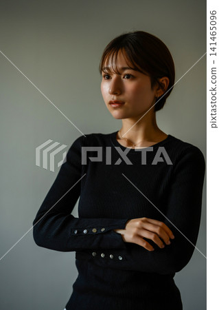 一位年輕女子雙手交叉在胸前看著我。 141465096