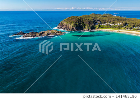 Aerial view of Sugarloaf Point surrounded by crystal-clear turquoise waters and the rugged coastline at Seal Rocks, NSW, Australia, highlighting the natural beauty of this iconic coastal headland. Aerial view of Sugarloaf Point surrounded by crystal-clear turquoise waters and the rugged coastline at Seal Rocks, NSW, Australia, highlighting the natural beauty of this iconic coastal headland. 141465186