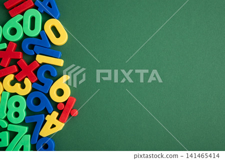 Colorful plastic numbers and math symbols on green background 141465414