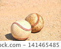 A baseball rolling on a dirt field 141465485