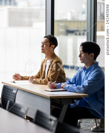 Two men listening to a lecture in a conference room Two men listening to a lecture in a conference room 141465698