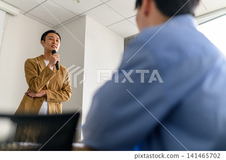 一個用麥克風說話的男人 141465702