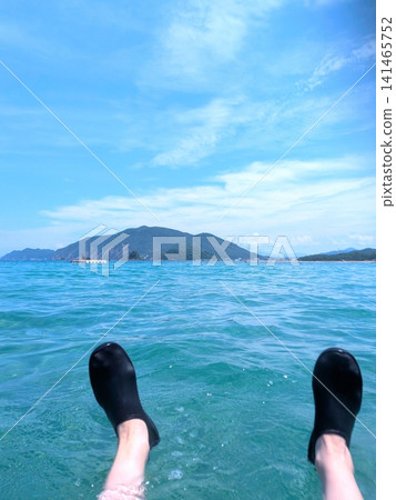 A first-person perspective of enjoying summer while floating on a clear sea. A first-person perspective of enjoying summer while floating on a clear sea. 141465752