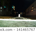 The railway tracks at night as seen from a level crossing. 141465767