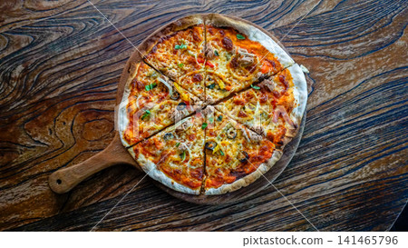 Top View Whole Italian Pizza on Wooden Pizza Peel with Copy Space, Homemade Cheese Pizza with Tuna, Onion, Olive and Bell Pepper on Rustic Table 141465796