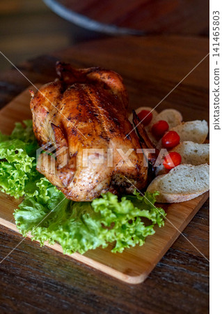 Whole Roasted Chicken Served with Fresh Lettuce, Bread and Cherry Tomatoes on Wooden Board, Rustic Restaurant Style Poultry Dinner Whole Roasted Chicken Served with Fresh Lettuce, Bread and Cherry Tomatoes on Wooden Board, Rustic Restaurant Style Poultry Dinner 141465803