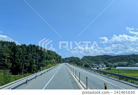 A summer highway scene with blue skies and cumulus clouds. A summer highway scene with blue skies and cumulus clouds. 141465830