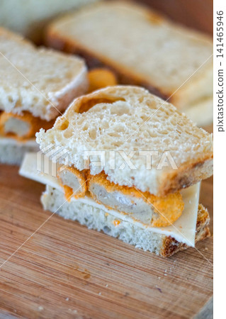 Simple homemade sandwich with fried filling and cheese on rustic bread close up, quick easy meal concept, minimal food styling with selective focus Simple homemade sandwich with fried filling and cheese on rustic bread close up, quick easy meal concept, minimal food styling with selective focus 141465946