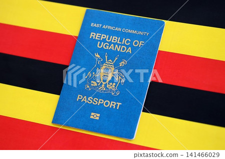 Ugandan passport on flag close up. Official identification document book for citizens of Uganda Ugandan passport on flag close up. Official identification document book for citizens of Uganda 141466029