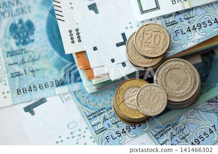Polish zloty money bills and grosz coins pile on table. Poland coins on banknotes of PLN currency Polish zloty money bills and grosz coins pile on table. Poland coins on banknotes of PLN currency 141466302