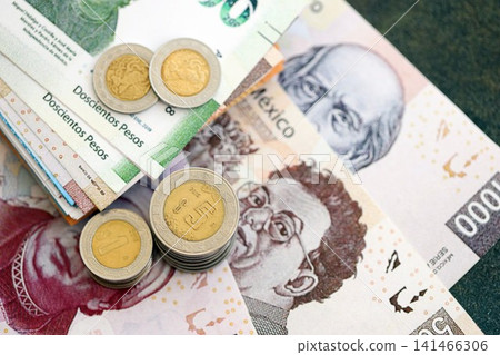 Mexican peso money bills and centavo coins pile on table. Mexico coins on banknotes of MXN currency 141466306