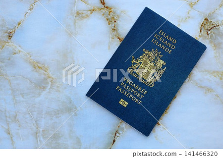 Icelandic passport on table close up. Official identification document book for citizens of Iceland Icelandic passport on table close up. Official identification document book for citizens of Iceland 141466320