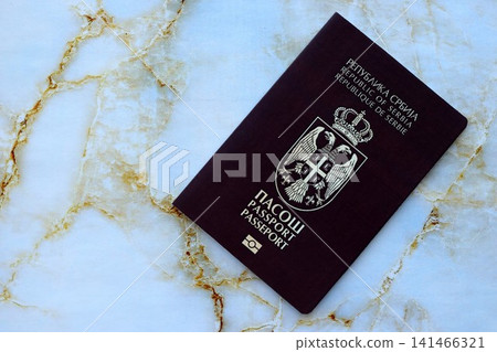 Serbian passport on table close up. Official identification document book for citizens of Serbia Serbian passport on table close up. Official identification document book for citizens of Serbia 141466321