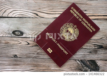 Uzbek passport on table close up. Official identification document book for citizens of Uzbekistan Uzbek passport on table close up. Official identification document book for citizens of Uzbekistan 141466322