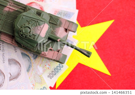 Vietnamese dong currency money bills and toy tank on flag. The concept of army funds and weapons sales 141466351