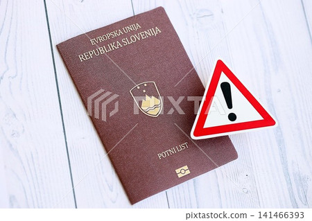 Slovenia passport with exclamation sign on wooden table. Problems with citizenship in Europe Slovenia passport with exclamation sign on wooden table. Problems with citizenship in Europe 141466393
