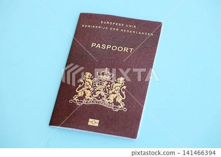 Netherlands passport on light blue paper background. Citizenship and travel in Europe Netherlands passport on light blue paper background. Citizenship and travel in Europe 141466394