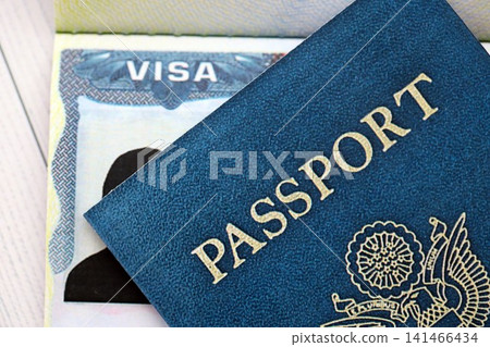 USA visa in an open passport page and United States passport cover on background USA visa in an open passport page and United States passport cover on background 141466434