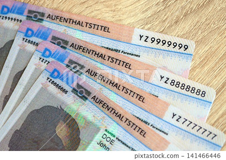 German Permanent resident specimen cards lies on wooden table. Aufenthaltstitel German Permanent resident specimen cards lies on wooden table. Aufenthaltstitel 141466446