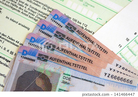 German Permanent resident specimen cards lies on german tax form. Aufenthaltstitel German Permanent resident specimen cards lies on german tax form. Aufenthaltstitel 141466447