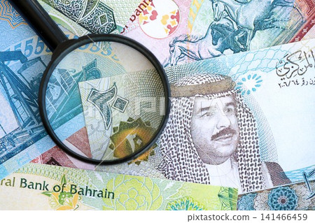 Bahraini dinar currency money bills and magnifying glass. The concept of financial monitoring Bahraini dinar currency money bills and magnifying glass. The concept of financial monitoring 141466459