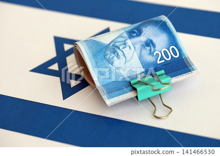 Israel New Shekels banknotes on national flag. The current Israel money bills lies on flag in big amount Israel New Shekels banknotes on national flag. The current Israel money bills lies on flag in big amount 141466530