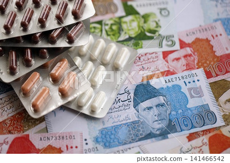 Pakistan rupees banknotes and medicine pills. Pakistan money bills with drugs close up Pakistan rupees banknotes and medicine pills. Pakistan money bills with drugs close up 141466542