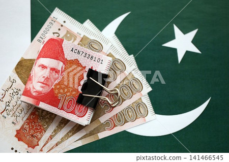 Pakistan rupees banknotes on Pakistani flag. The current Pakistan money bills Pakistan rupees banknotes on Pakistani flag. The current Pakistan money bills 141466545