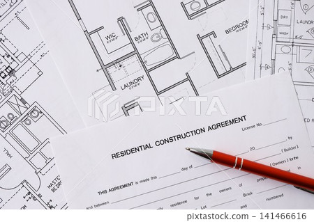 Pen on residential construction agreement and planning blueprints of residential building project Pen on residential construction agreement and planning blueprints of residential building project 141466616