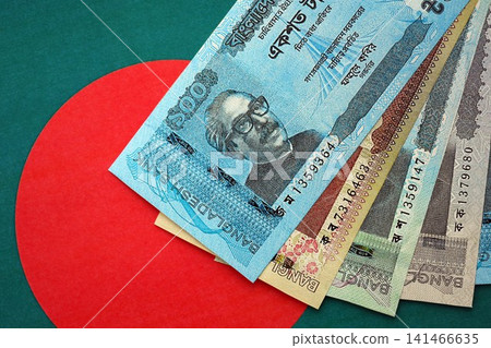 Bangladeshi taka money bills in big amount lies on Bangladesh flag close up Bangladeshi taka money bills in big amount lies on Bangladesh flag close up 141466635