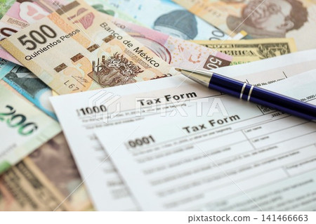Big amount of money bills of different currencies and countries and tax report blank form 141466663