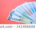 South Korean won money bills in big amount lies on red color table close up 141466688