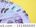 Mexican pesos money bills in big amount lies on yellow color table close up 141466689