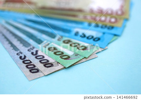 Bangladeshi taka money bills in big amount lies on teal color table close up Bangladeshi taka money bills in big amount lies on teal color table close up 141466692