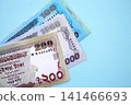 Bangladeshi taka money bills in big amount lies on teal color table close up 141466693